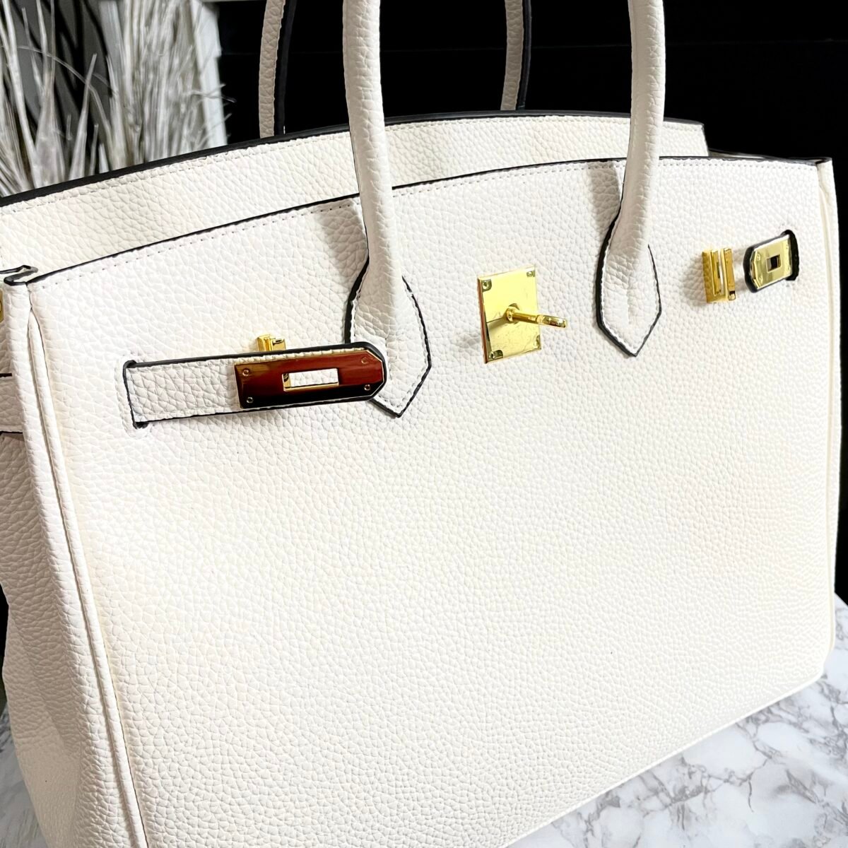 "Leather Top Handle Handbag designed for everyday luxury. This luxury-inspired tote offers premium leather, structured shape, top handles, secure lock closure, and classic elegance—perfect for office, travel, and daily wear. Shop the quiet luxury bag women are searching for."