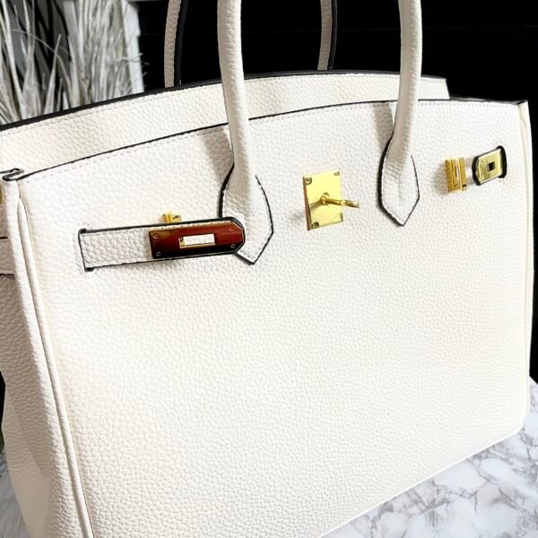 "Leather Top Handle Handbag designed for everyday luxury. This luxury-inspired tote offers premium leather, structured shape, top handles, secure lock closure, and classic elegance—perfect for office, travel, and daily wear. Shop the quiet luxury bag women are searching for."